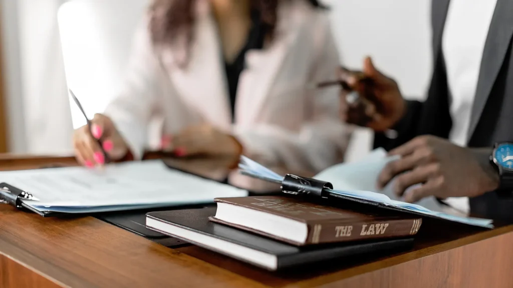 Lawyers in discussion with legal books and documents on table.